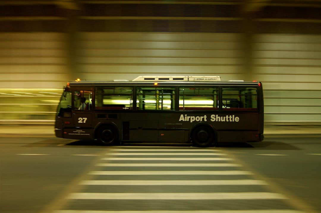 red and black bus on gray road — Photo by Markus Krisetya on Unsplash
