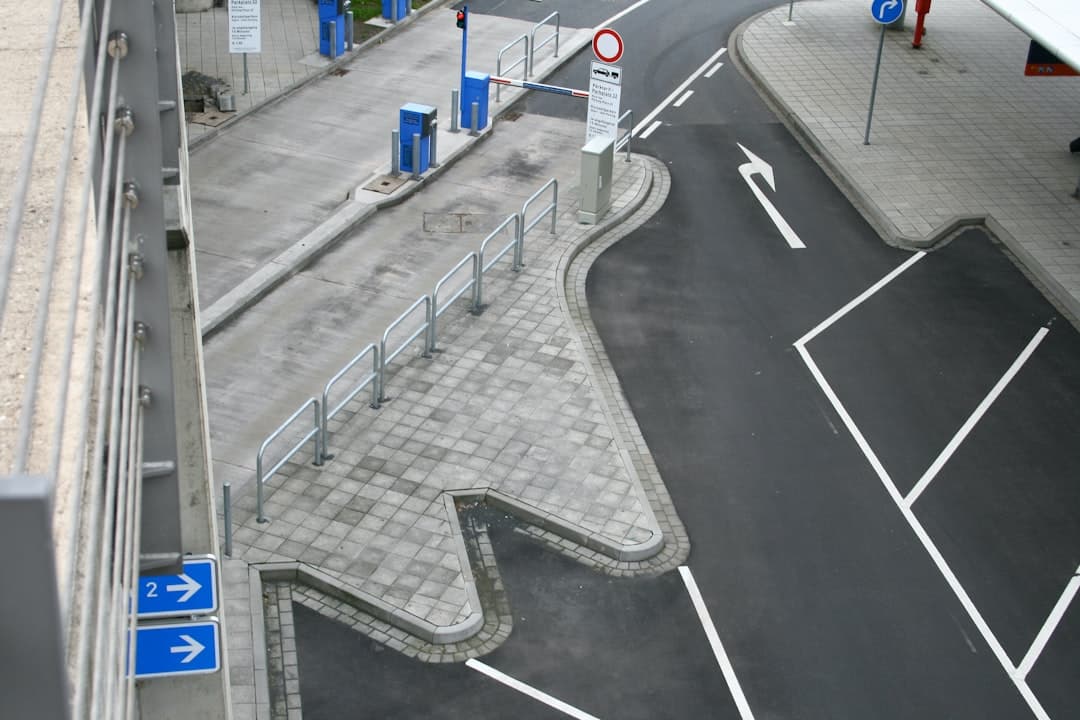 Urban road junction with white markings, paving, and a building. — Photo by Alto Mezger on Unsplash