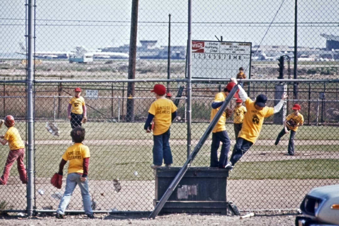 a group of young men standing on top of a baseball field — Photo by Documerica on Unsplash