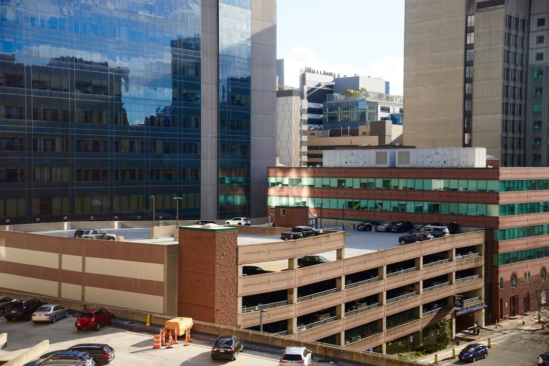 Cars parked on multi-level parking garage with city buildings. — Photo by Brett Wharton on Unsplash